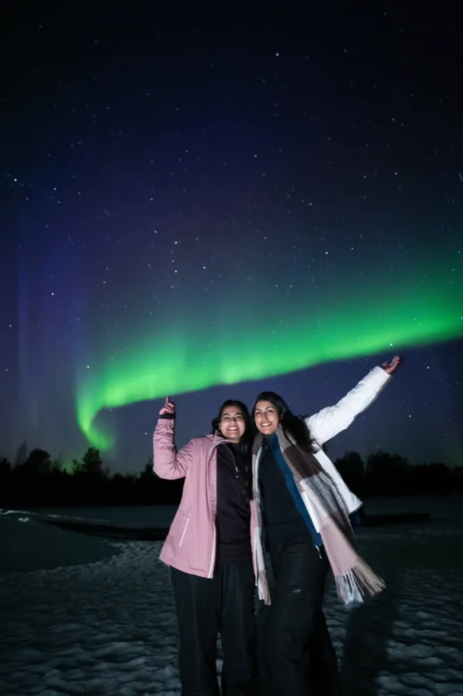 Guests pointing at the Northern Lights on an Experience Tours hunt